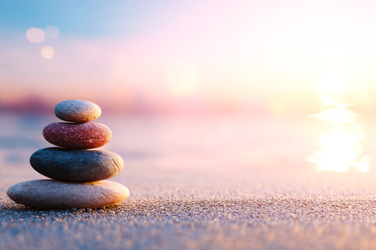 A serene stack of pebbles on the beach, symbolizing balance and tranquility at sunset, perfect for mindfulness and relaxation.
