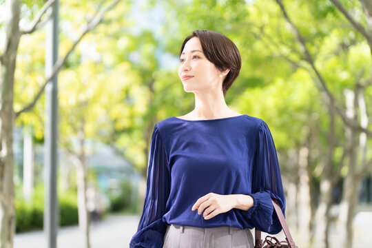 並木道を歩いている女性
