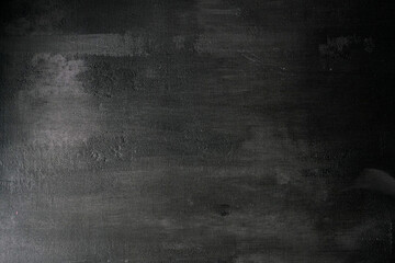 Abstract black grunge textured background for creative projects with scratches, roughness and abrasions.