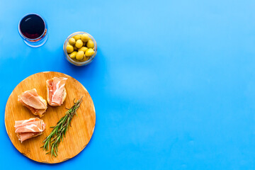 Spanish meal. Prosciutto ham on wooden board and glass of wine