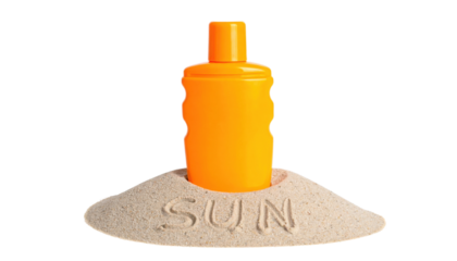 An orange sunscreen bottle standing upright in a mound of sand with the word "SUN" written in the sand.