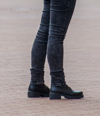 A woman is wearing black jeans and boots