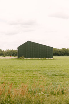 A barn from the side in a field.