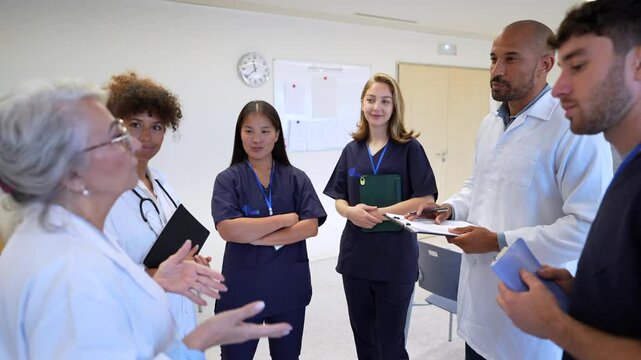Medical team discussing patient charts in hospital corridor