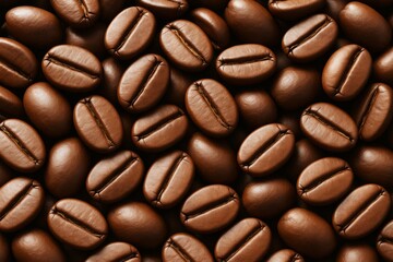 Close-up of roasted coffee beans with smooth texture and warm lighting on an abstract background to represent drink ingredients and caffeine concept.