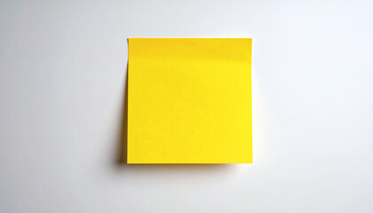 Fototapeta premium Yellow post-it paper note on white wall background with empty space for reminders and messages