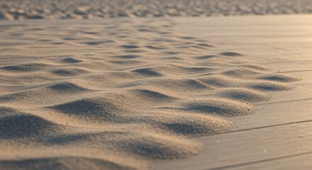 Obraz premium Close-up of textured sand patterns on a beach at sunset 