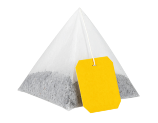 A pyramid-shaped tea bag with a yellow tag attached by a string.