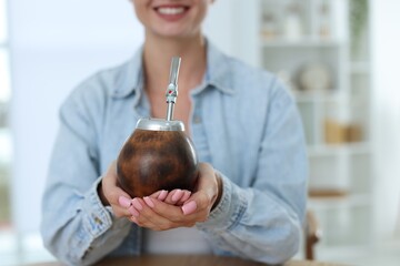 Woman with traditional yerba mate tea indoors, closeup