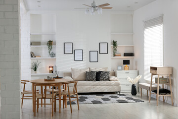 Comfortable sofa, table, chairs and dresser indoors. Interior design