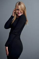 Fototapeta premium Elegant Woman in Black Dress Posing with Confidence and Charm..