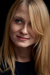 Close-Up Portrait of a Freckled Woman With Blonde Hair and Bright Eyes..