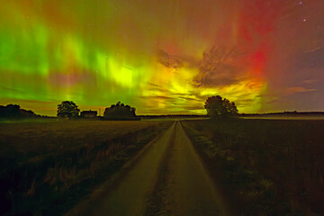 Northern lights dancing over country landscape 