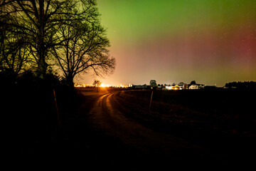 Northern lights dancing over country landscape 