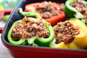 Close-up of colorful bell peppers stuffed with seasoned ground beef, ready for baking. A vibrant and appetizing preparation scene showcasing a classic homemade dish