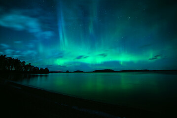 Moon light lake with a dancing northern lights in Farnebofjarden national park in north of Sweden.