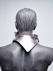 Rear view of a stylized mannequin wearing a polished steel gorget with a pointed backplate and...