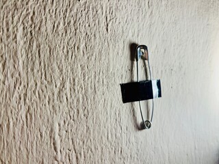 Safety pins duct-taped to the wall