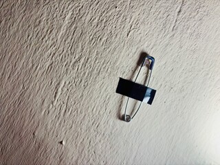Safety pins duct-taped to the wall