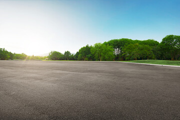 Panoramic empty tarmac floor at the beautiful green park under blue sky at morning.