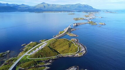 Aerial drone view of the Atlantic Ocean Road (Atlanterhavsveien) in Norway. The beauty of Norway’s coastline, where vehicles travel along a magnificent road surrounded by serene waters and green hills