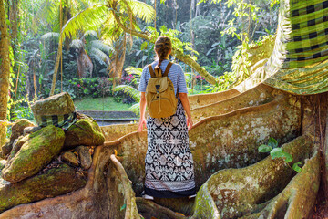 Female tourist with backpack enjoying view of a tropical forest
