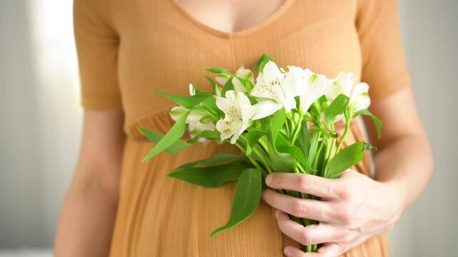 Delicate white blossoms complement expecting mother's gentle belly caress. Intimate moment of pregnancy joy and natural beauty.