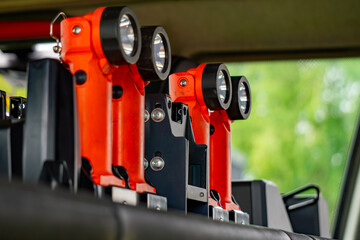 red rechargeable flashlights mounted in holders inside a fire truck. Essential equipment ready for use during rescue operations and emergency response