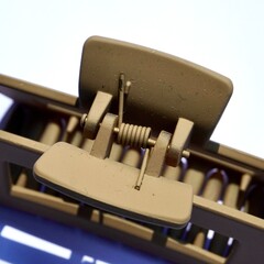 Close up brown hair claw spring object isolated on square white colored background.