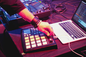 DJ performs in nightclub with cold lighting creating vibe. DJ equipment closeup