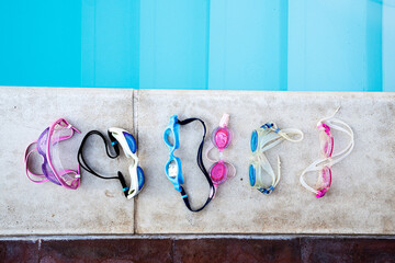 Summer Swim Essentials: Colorful Goggles Lined Up by the Pool for Aquatic Training.