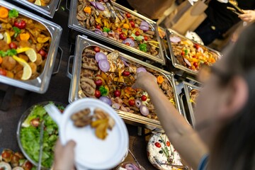 Crowd gathers around buffet with diverse dishes at culinary event in evening