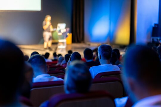Audience engaging with speaker during an educational presentation in a theater setting at a conference event
