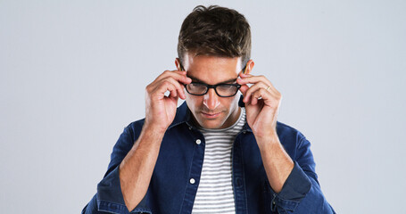 Man, glasses and touch in studio for vision, optometry or adjusting to new lens for sight. Person, prescription specs and testing on white background space for eye care, designer frames or healthcare
