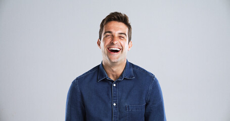 Portrait, funny and man in studio, humor and laughing with positive mindset on gray background...