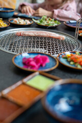 A table with plates of food and a grill for cooking