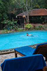 A man is currently swimming in a large swimming pool area