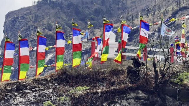 Vibrant Buddhist prayer flags flutter in the Himalayan wind along the Everest Base Camp trail, symbolizing peace and blessings.