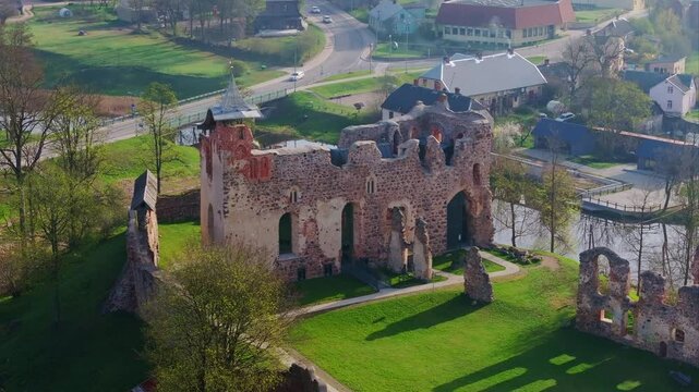Ancient stone castle walls stand tall on hill in Dobele, surrounded by spring