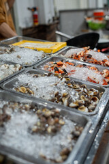 A collection of trays, each containing various types of seafood placed on ice