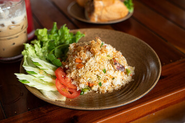 A plate of fried rice with tomatoes and lettuce on a table