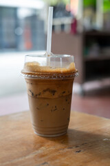 A refreshing cup of iced coffee with a straw placed on a wooden table