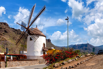 Historic windmill "Molino Quemado" in Mogan with mountain backdrop, Gran Canaria, Spain