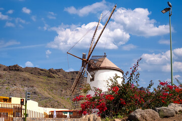 Historic windmill "Molino Quemado" in Mogan with mountain backdrop, Gran Canaria, Spain