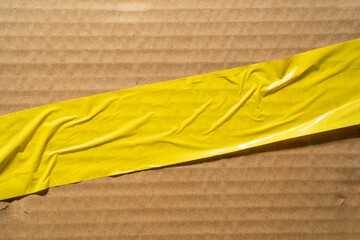Yellow parcel tape label on cardboard