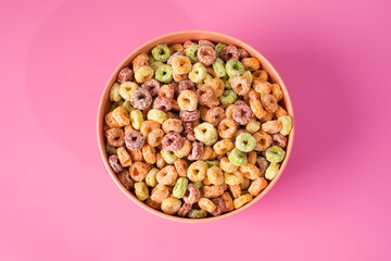 Colorful cereal bowl on pink background for breakfast concept