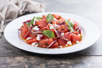 Fresh Watermelon Feta Salad with Mint and Red Onion on wooden table