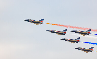 J-10 Acrobatic airshow team from China Air Force on formations with colorful smokes venting from...