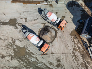Concrete trucks delivering mixtures at a construction site during the day