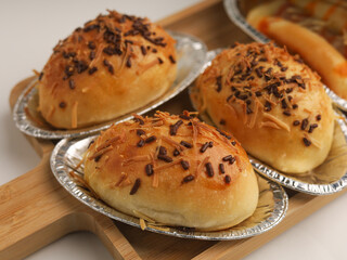 Sweet breads in aluminum foil on wooden tray